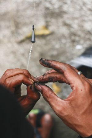 Close up of man putting bait on hook