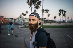 Bearded traveler on pavement in city