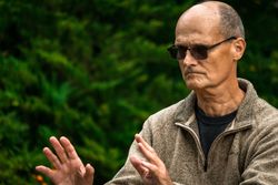 Older man practicing martial arts in countryside