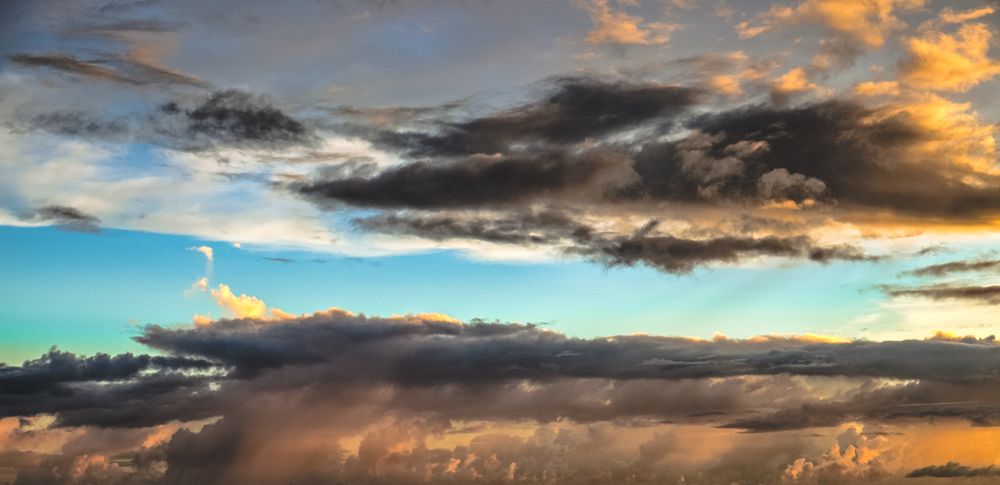 Dark grey clouds surrounding light blue sky