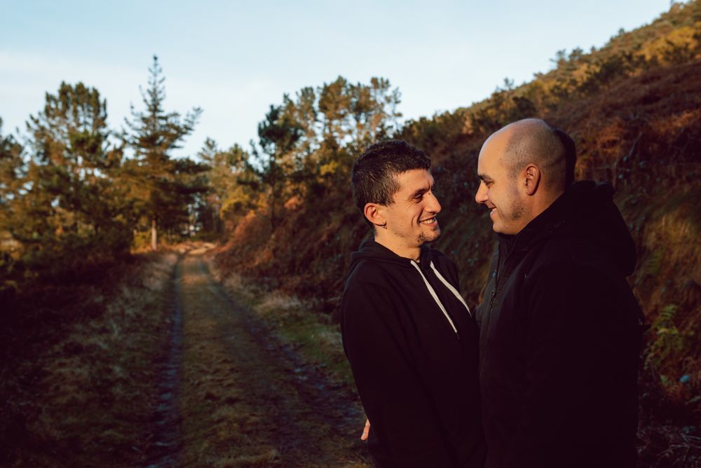 Smiling men hugging on countryside road