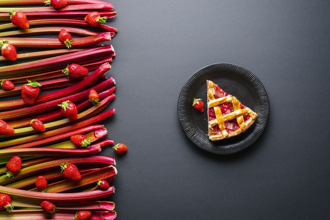 Slice of rhubarb-strawberries pie on a dark plate