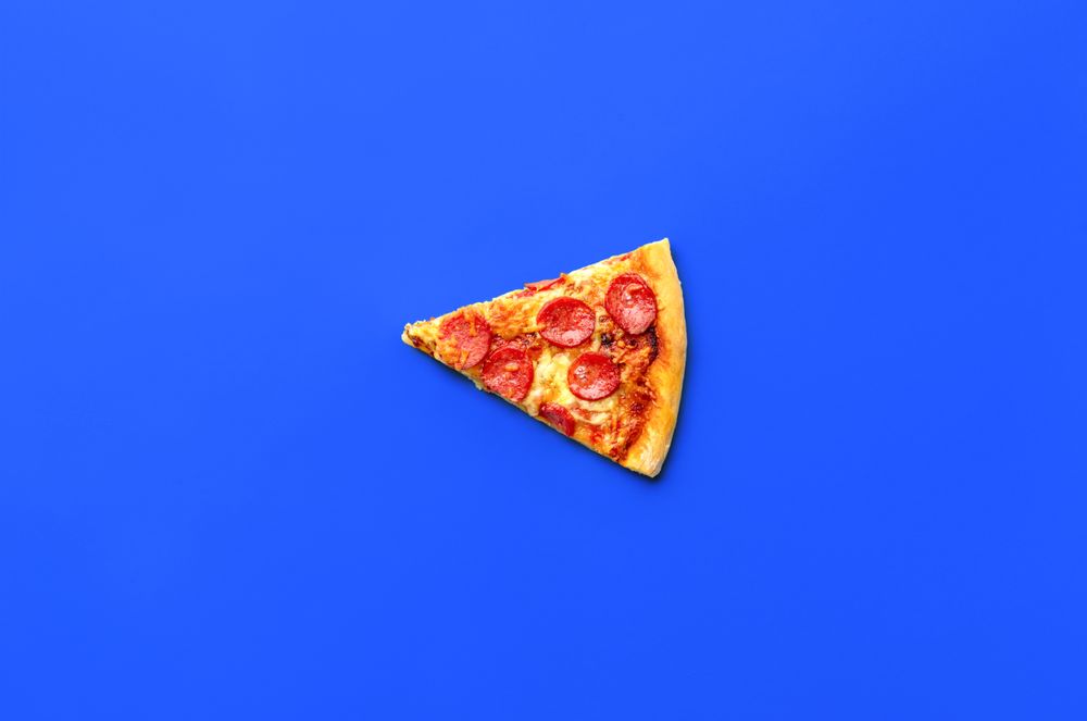 Slice of pepperoni pizza isolated on a blue background