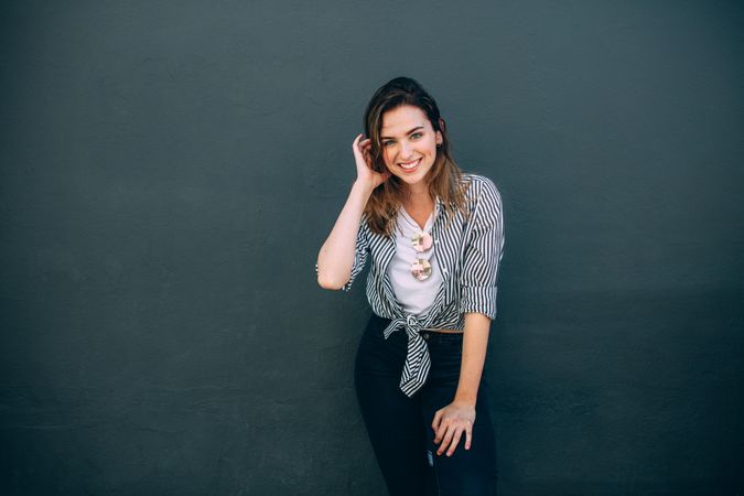 Happy looking woman standing against a wall