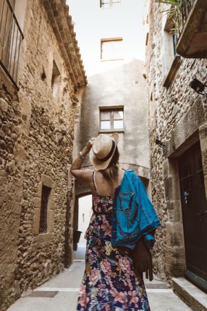 Woman walking in a narrow path in a village