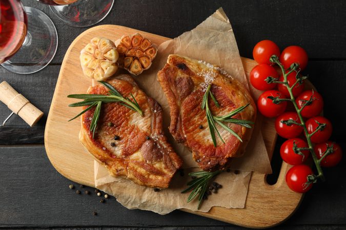 Composition with fried steaks on wooden background. Grilled food