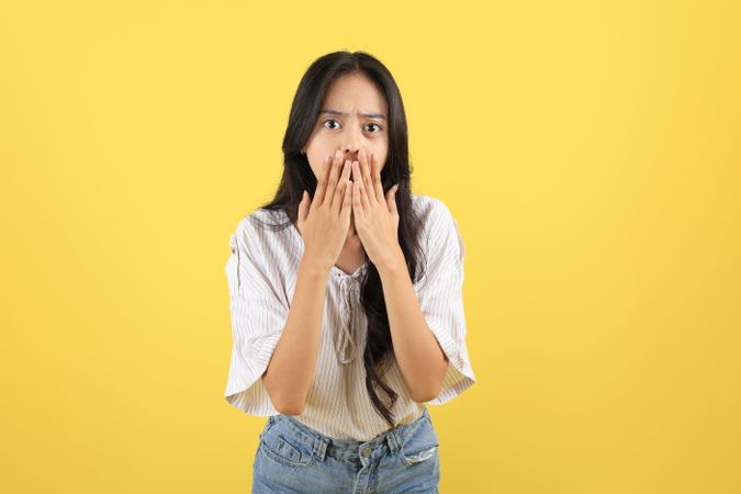 Young Asian Girl Gasping Amazed, Saying Wow, Covered Her Mouth with Palm, Eyes Bulging.