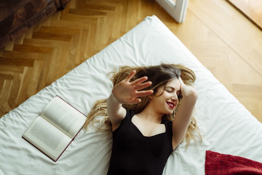 Young confident woman lying on bed