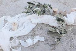 Olive tree branches, fruit with silk ribbons and muslin table runner