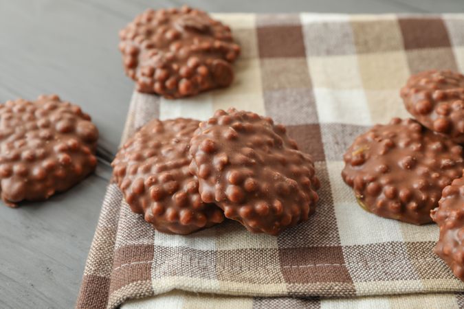 Kitchen towel with chocolate cookies on grey table, space for text