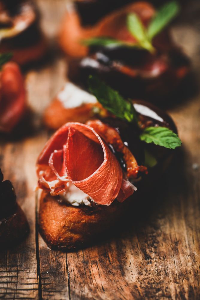 Crostinis with prosciutto, goat cheese and grilled figs, close up