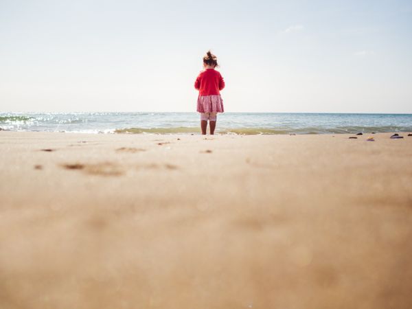Girl walking on beach in sunny day