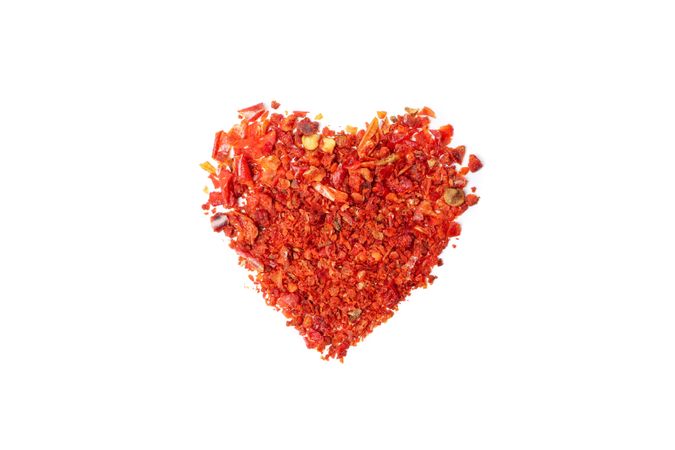 Heart made of pepper powder spice isolated on blank background