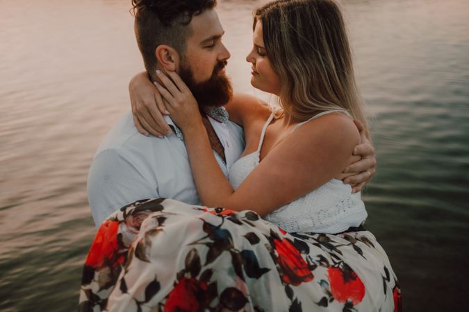 Loving couple standing ankle deep in water on beach
