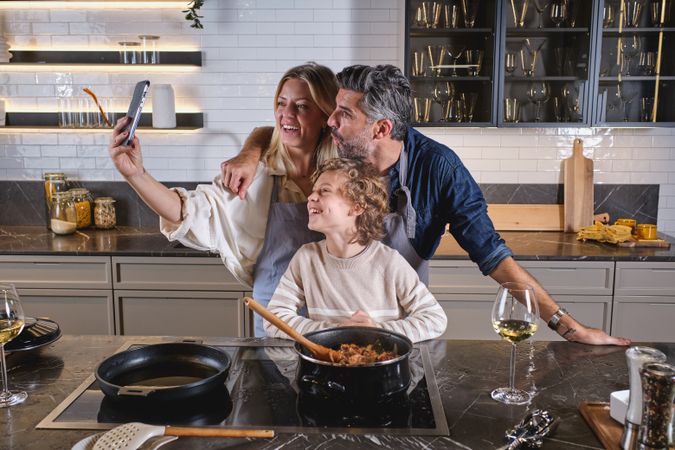 Happy multiethnic family taking selfie in kitchen