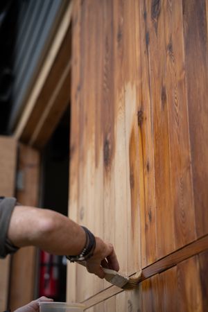 Oiling a big cedar door with danish oil using a natural bristled brush