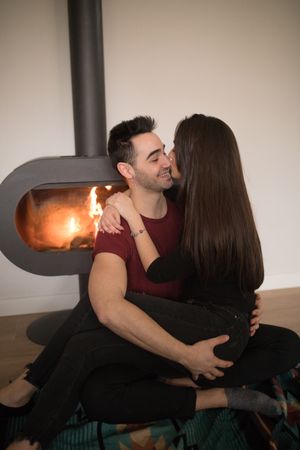 Couple sitting near fireplace on floor