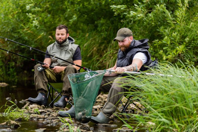 Fishermen by River with Catch