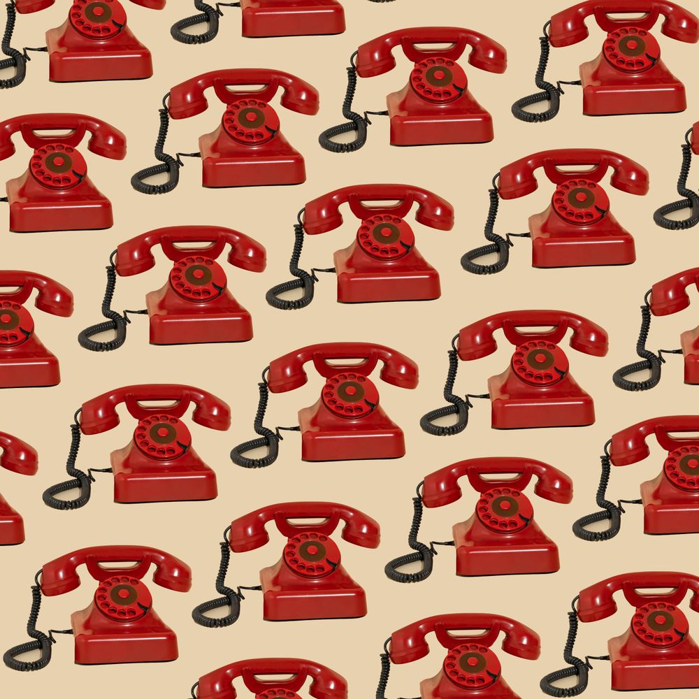 Rows of vintage red rotary phones.