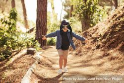 Cute boy with pilot goggles and hat running in forest 0PkXOb