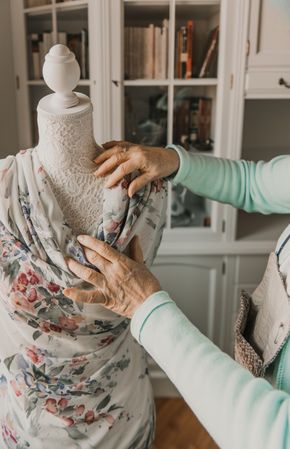 Dressmaker adjusting apparel on mannequin