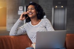 Woman smiling on phone call in atrium of building