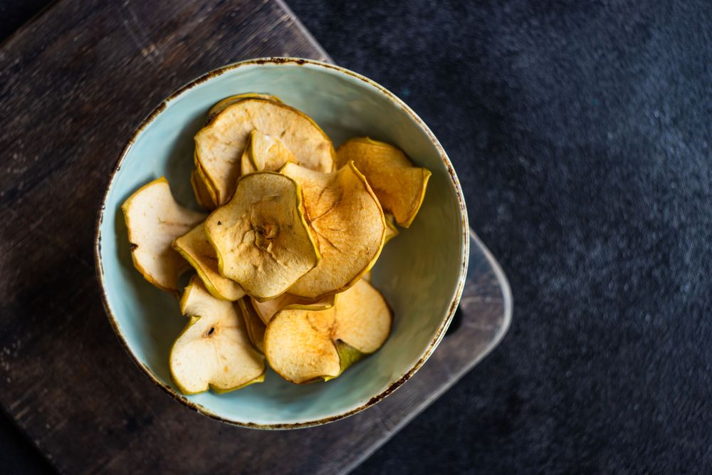 Top view of apple chips in rustic bowl