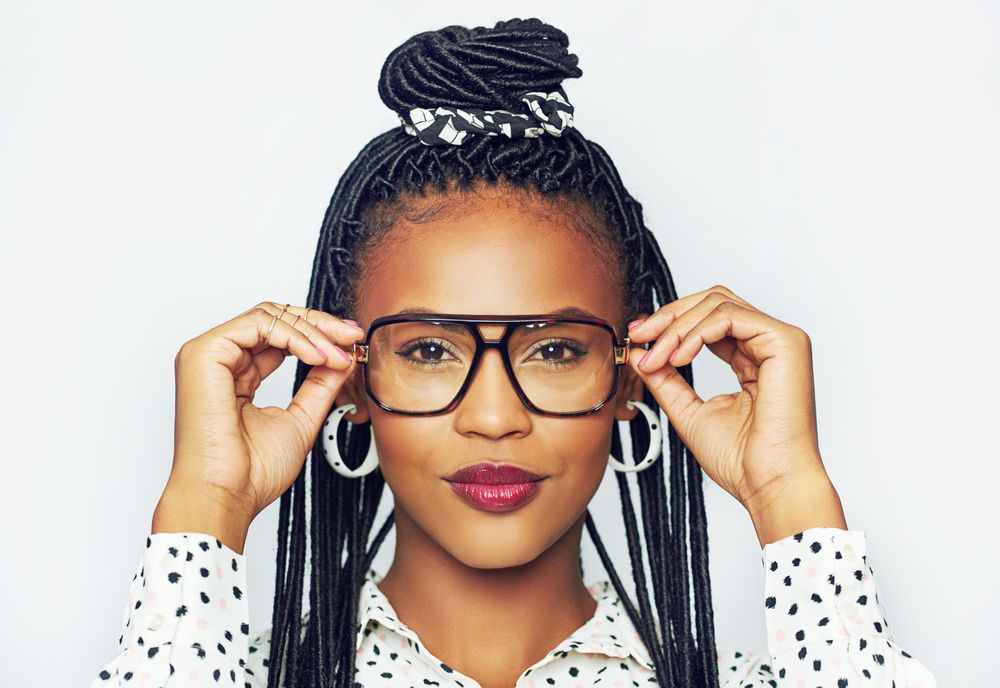 Studio portrait of serious woman wearing eyeglasses against a bright background