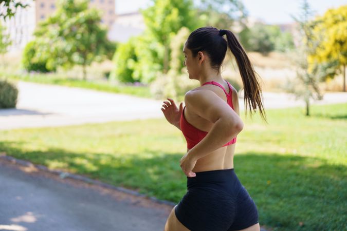 A woman jogging in a park to maintain her fitness level
