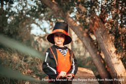 Boy in skeleton costume standing in the forest 4dLkr4