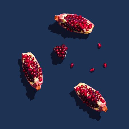 Minimal nature layout with pomegranate slices on navy  background