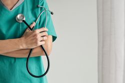 Faceless surgeon with crossed arms and stethoscope