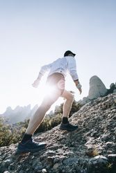 Athlete running up steep rocky trail