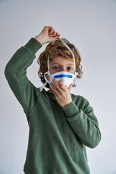 Child putting on medical respirator