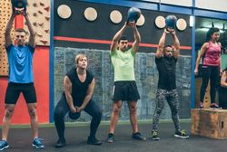 Athletes exercising with kettlebells indoors