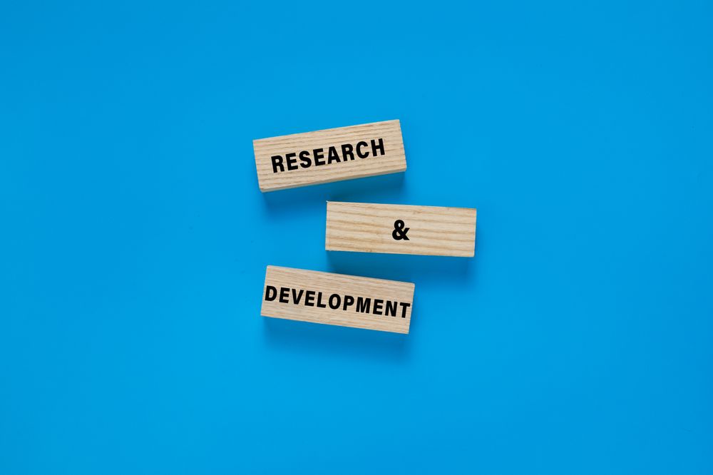 research and development words symbol on wooden blocks. isolated on blue background