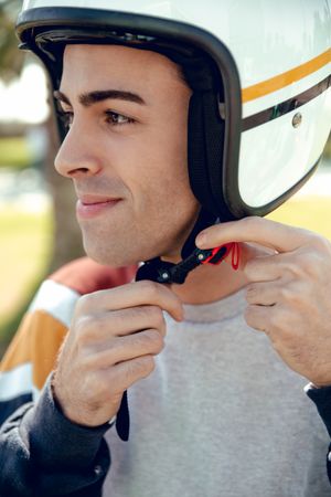 Man in motorcycle adjusting helmet