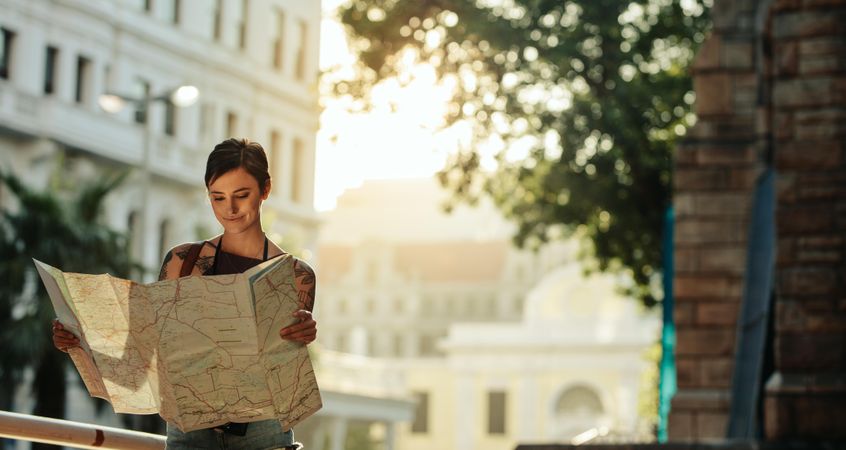 Woman tourist studying a map to explore the city