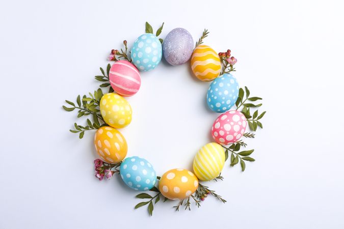 Decorative Easter eggs and flowers on neutral background, space for text. Top view
