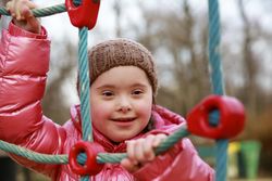 Close up of child climbing rope on playground set