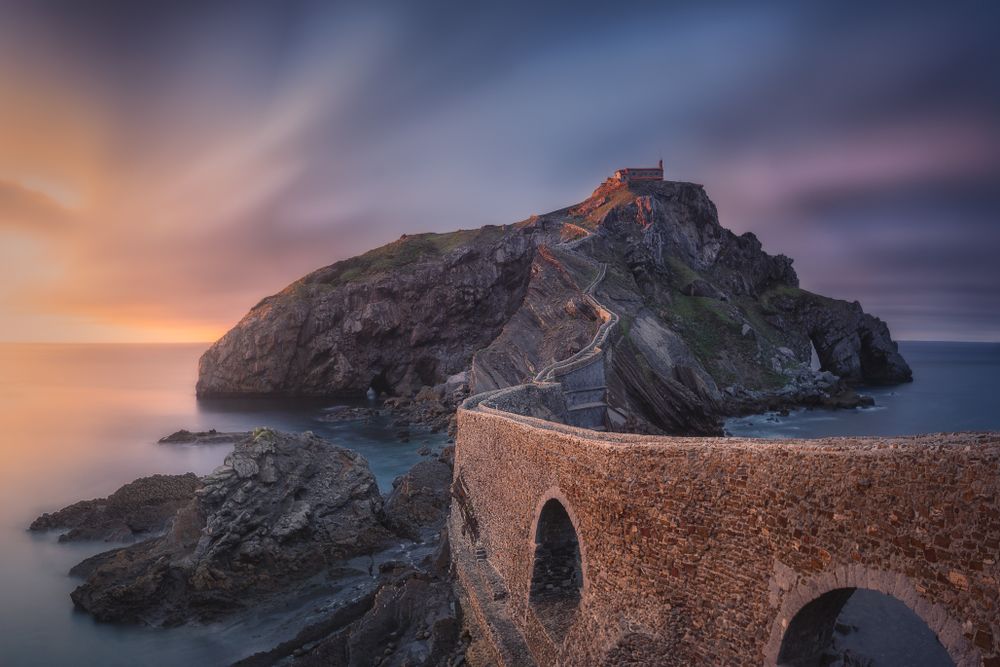 Lonesome rocky island with chapel and stone bridge