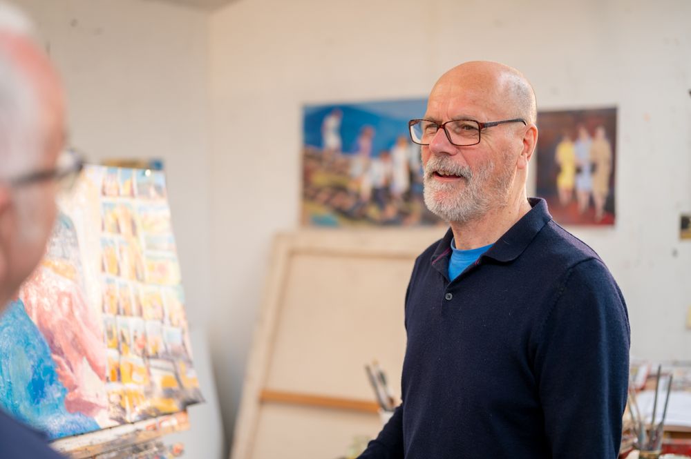 Male artist chatting with friend in studio