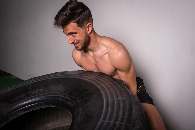 Man flipping big tires in gym