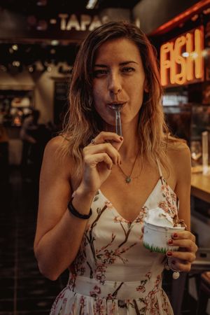 Woman enjoying tasty ice cream in bar