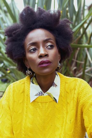 Portrait of woman with afro hair wearing yellow sweater