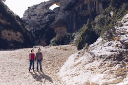 Woman and man standing on stones between high hills