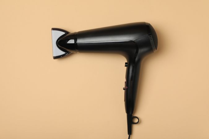hair dryer on beige background, space for text