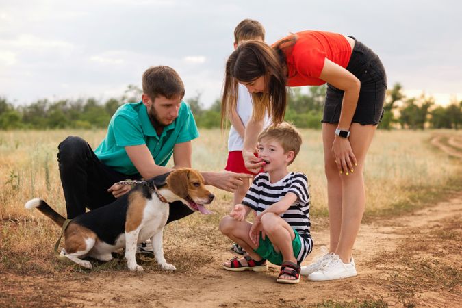Family walk the dog in field