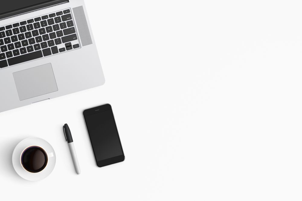 Modern workspace with coffee cup, smartphone and laptop copy space