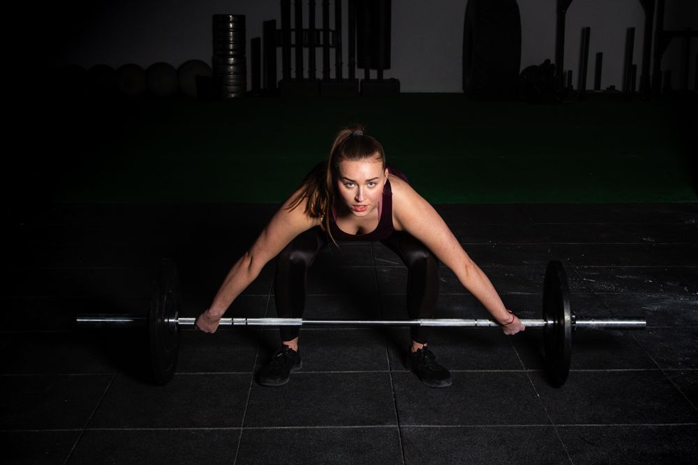 Woman lifting barbell in gym